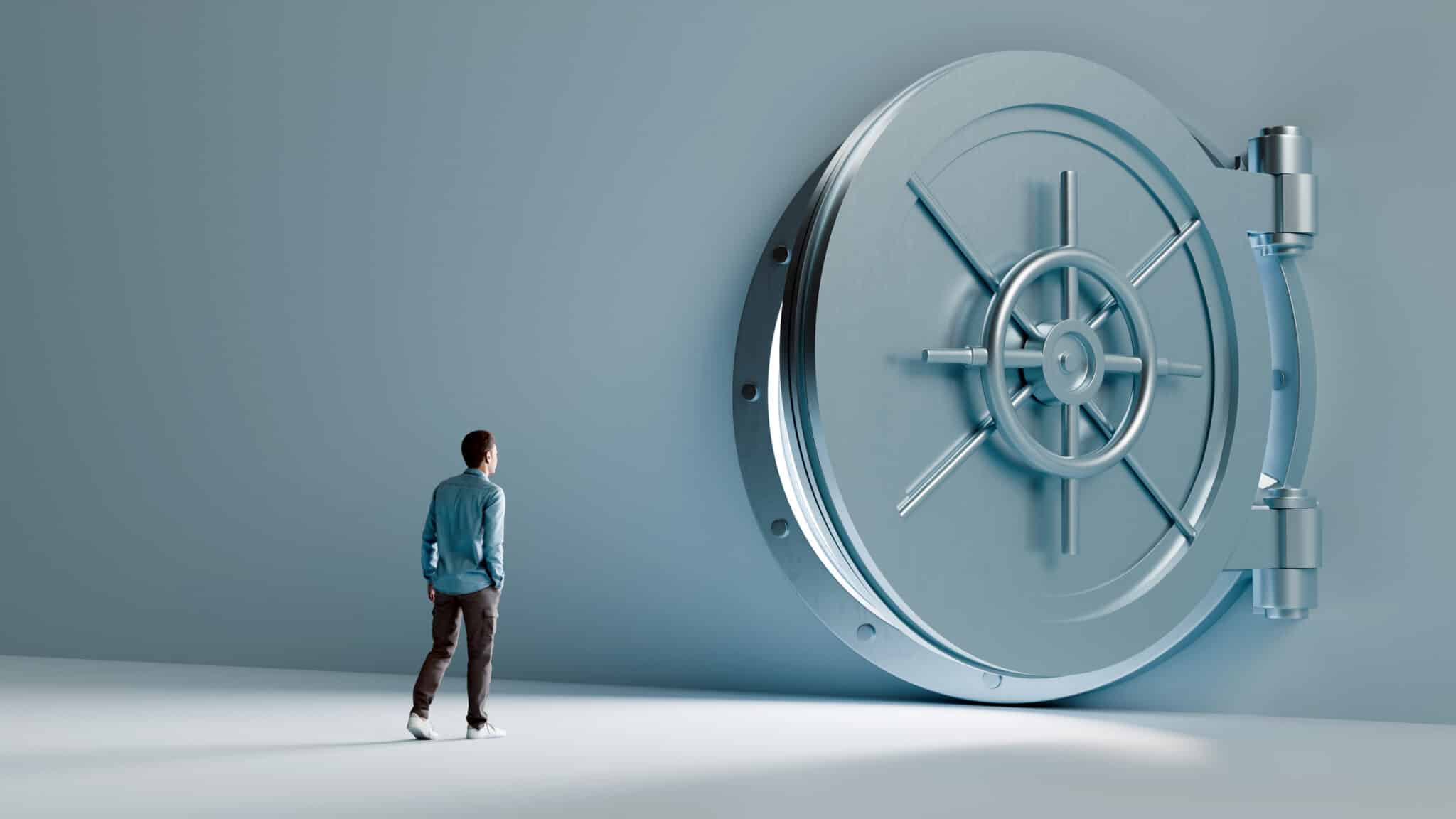 A man standing in front of a giant vault door is considering fast business funding options.