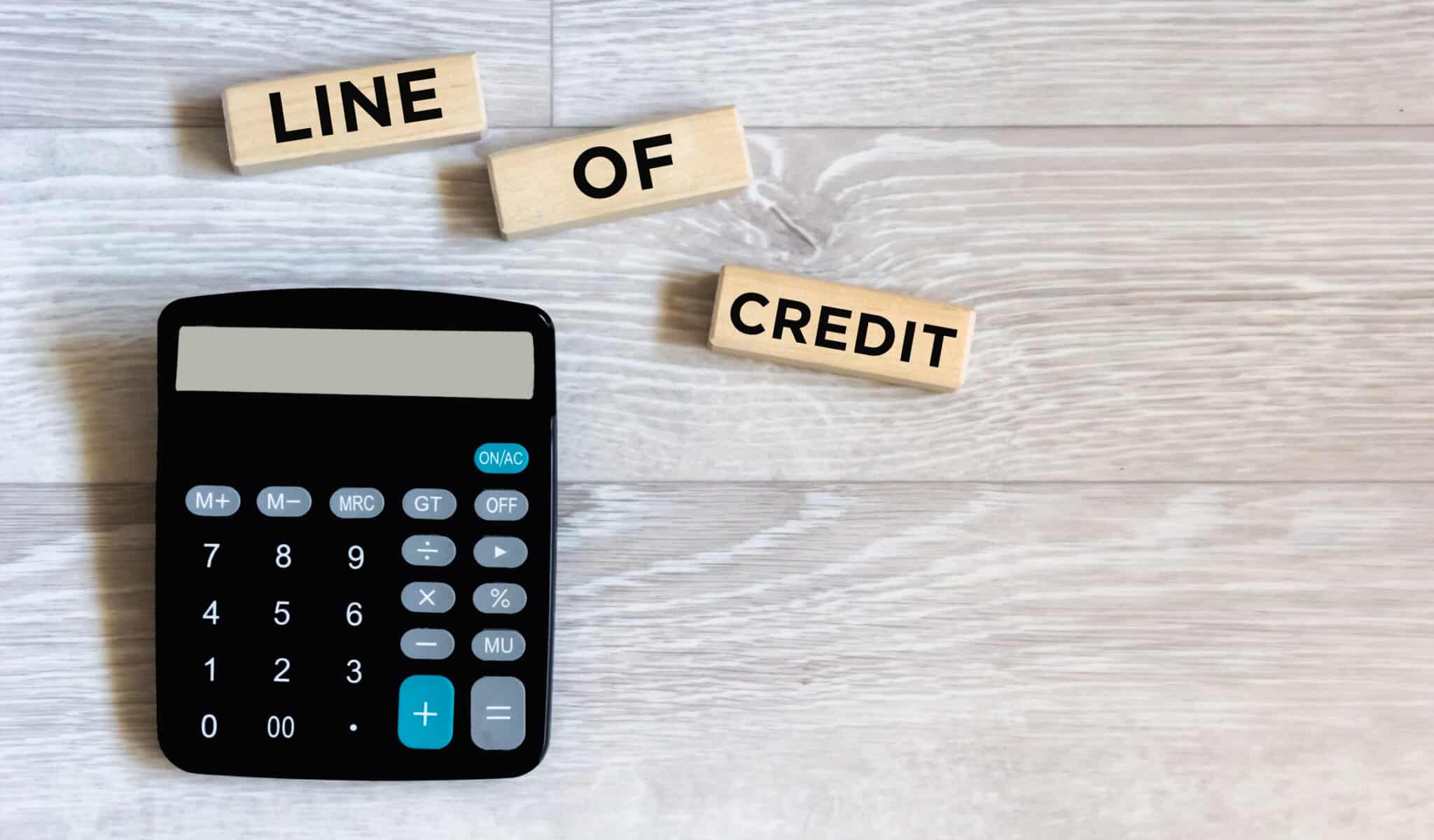 Calculator and wooden blocks with the inscription credit line. Workplace close-up. Business concept, Line of credit.